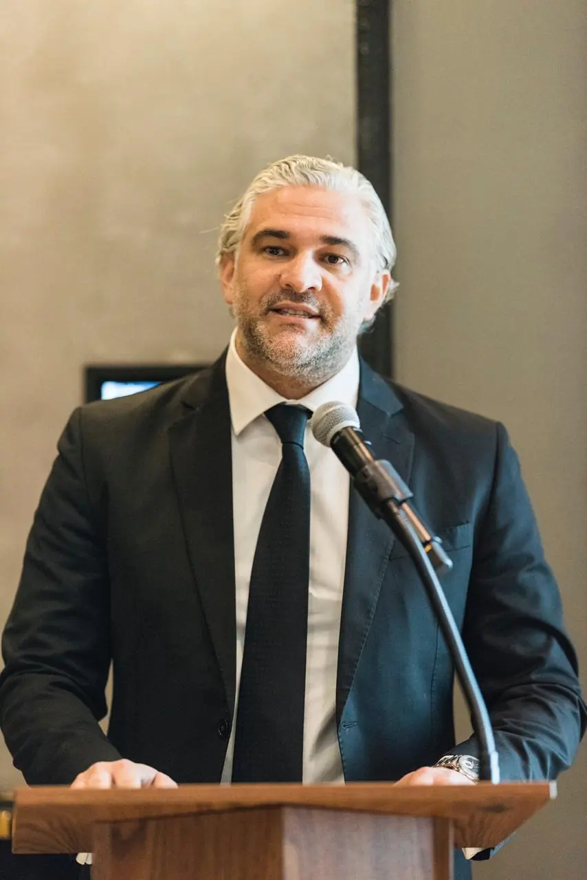 Billy Joueidi speaking at a podium